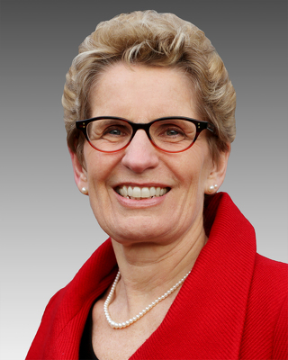 image Kathleen Wynne Premier of Ontario wearing pearls, glasses,red shirt